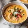 Creamy homemade cream cheese chicken chili in a white bowl, topped with melted cheese and fresh cilantro.