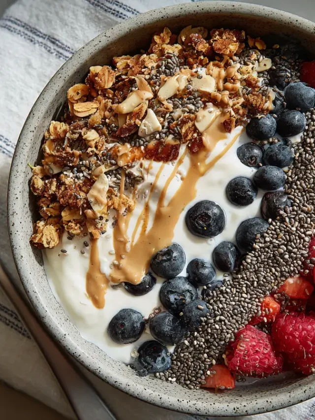 Protein-packed yogurt bowl with fresh blueberries, raspberries, strawberries, granola, and chia seeds