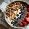Protein-packed yogurt bowl with fresh blueberries, raspberries, strawberries, granola, and chia seeds