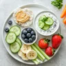 Low FODMAP diet snack plate with rice cakes, fruit, and vegetables