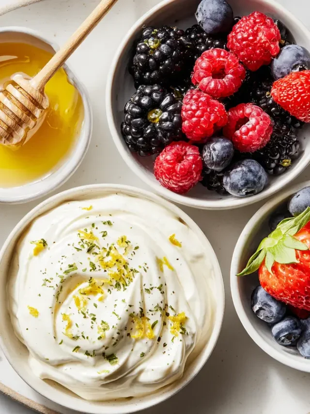 Whipped Greek yogurt with lemon zest, fresh berries, and honey in small bowls