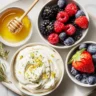 Whipped Greek yogurt with lemon zest, fresh berries, and honey in small bowls